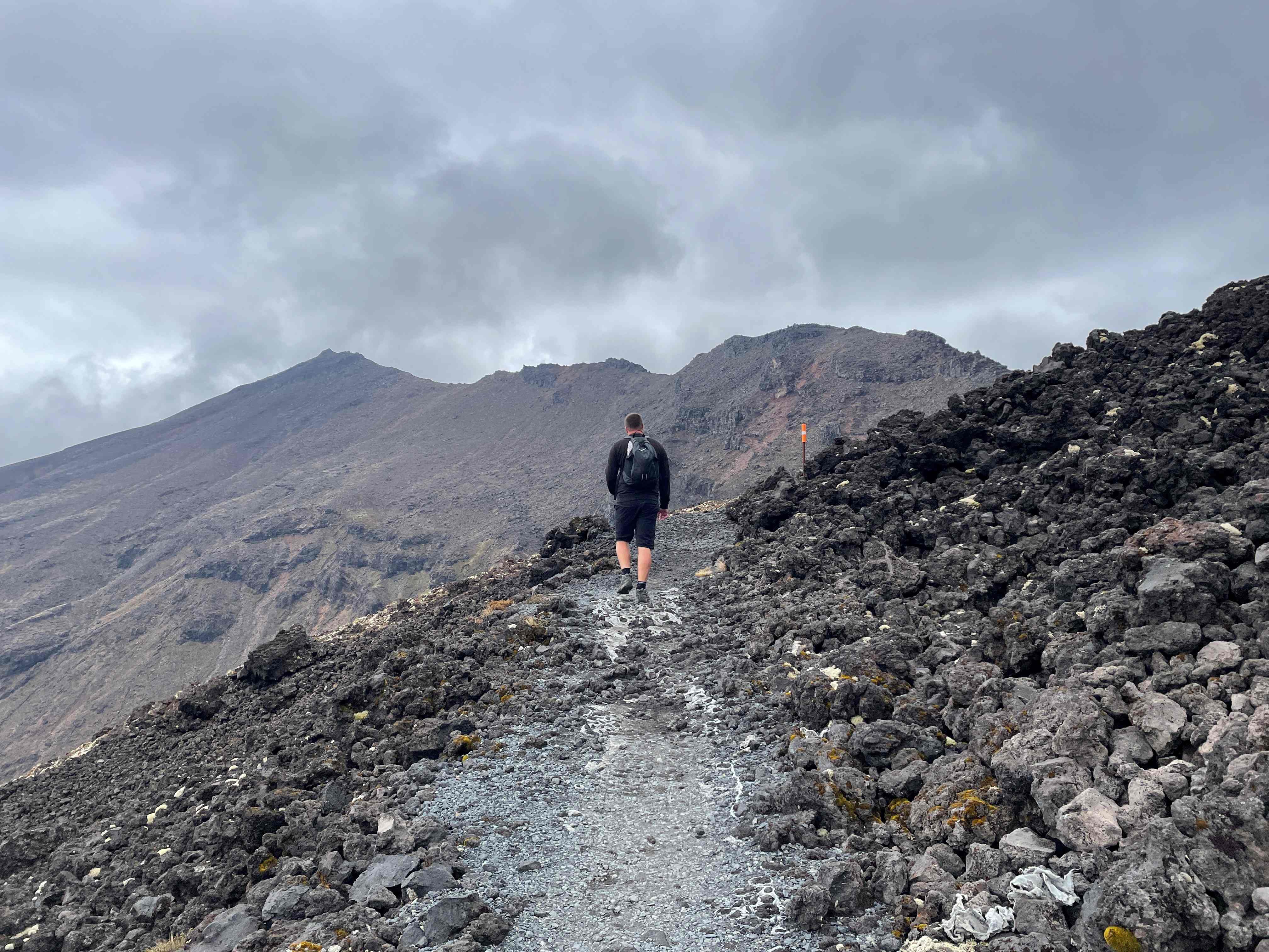 Man hiking dow the Tongariro Alpine Crossing - Visit Ruapehu.jpg