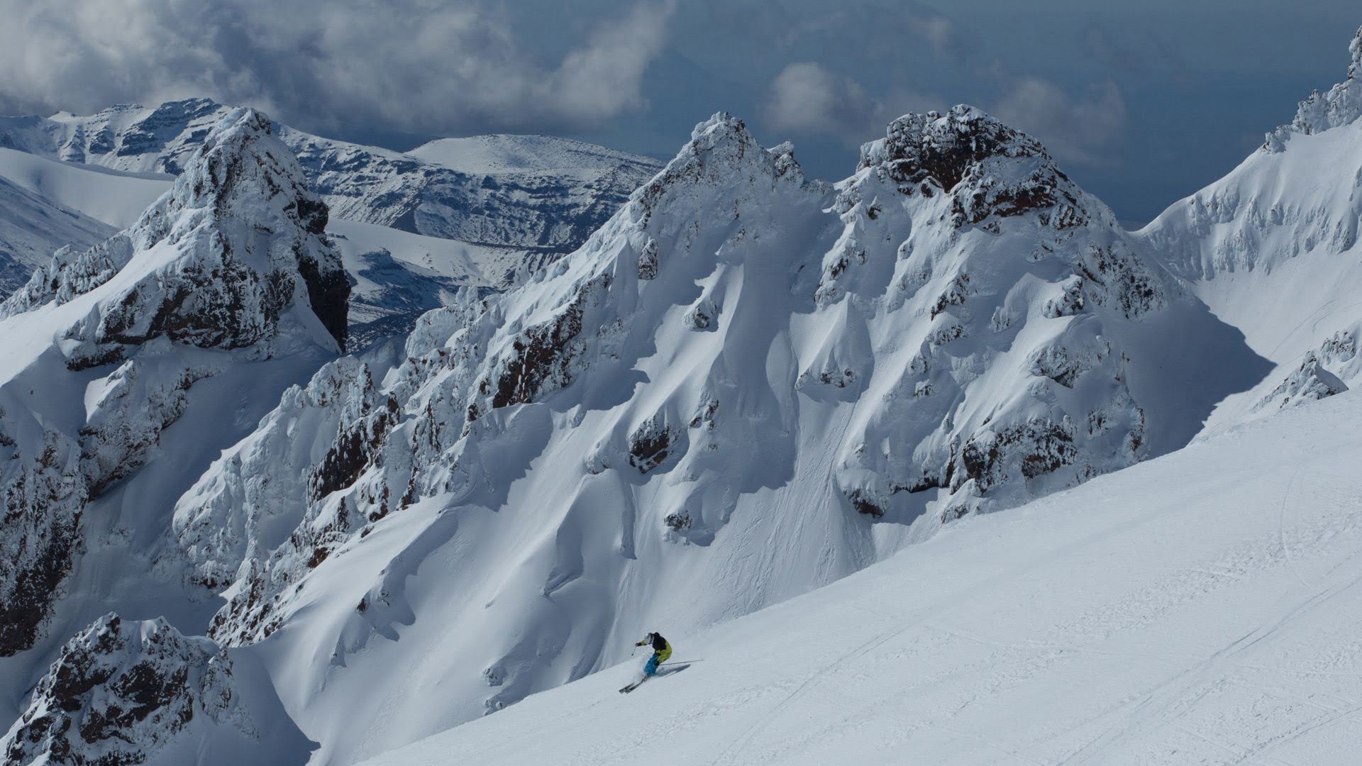 Skiier at Whakapapa Ski Area with the PInnacles in the background, Mt Ruapehu - Visit Ruapehu