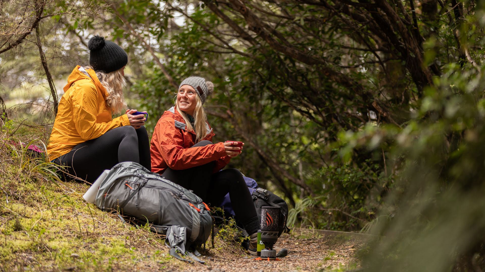 Two friends enjoying a drink mid hike - Visit Ruapehu
